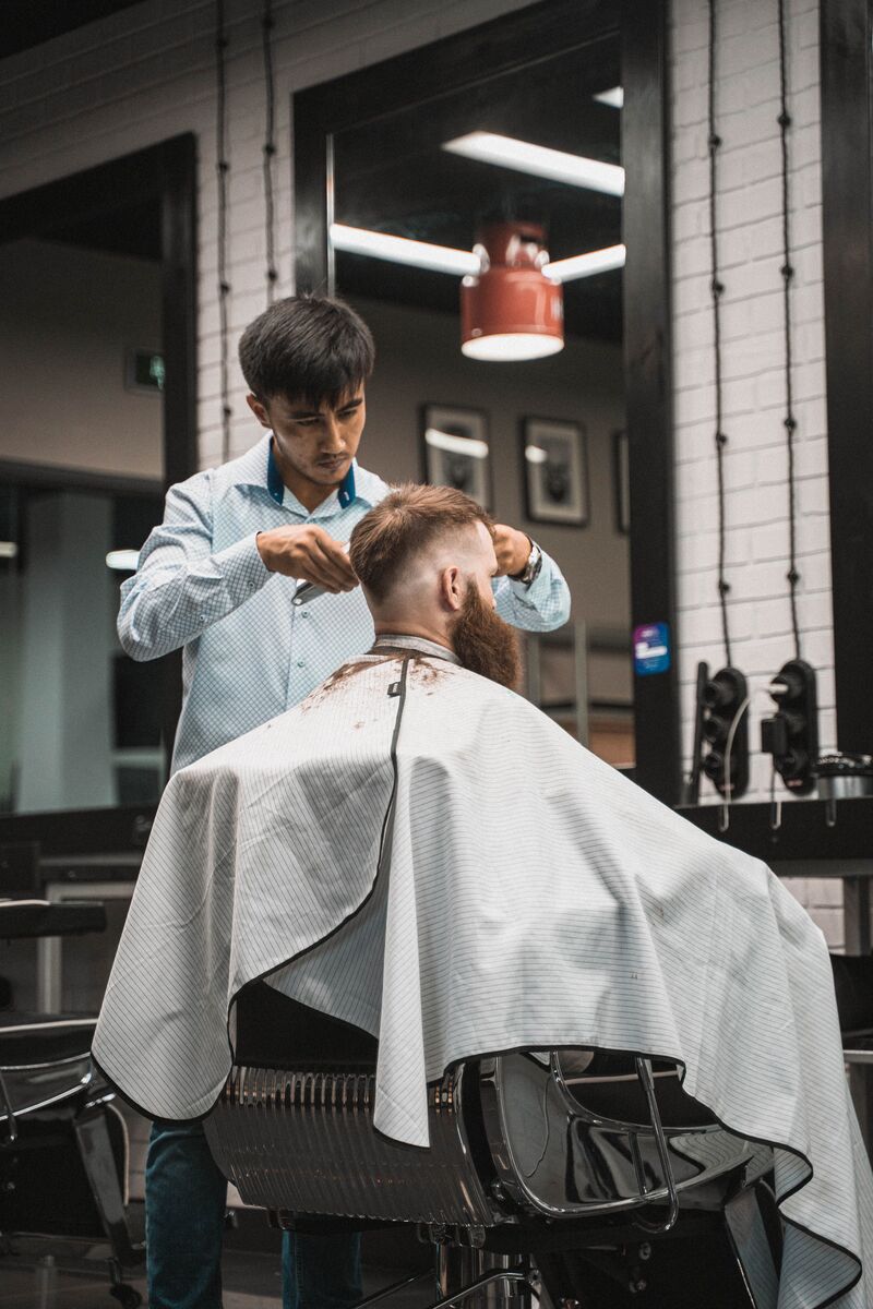 Clipper fade on the back with a shaped beard in a modern shop